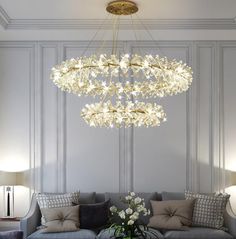 a living room filled with furniture and a chandelier hanging over the top of it