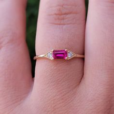 a woman's hand with a pink tourmaline and diamond ring