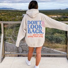 "This oversized hoodie is the perfect way to stay cozy and comfy while looking stylish. The unisex design features a hood, long sleeves, and a kangaroo pocket. The back proudly displays the words \"Sony look back you're not going that way\" in a bold retro font to remind the person behind you to stay positive. The hoodie is made from super soft fabric for extra comfort, and the relaxed fit ensures you'll look great no matter how you wear it. Gildan 18500 50% cotton, 50% polyester Medium-heavy fabric  Classic fit Tear-away label Runs true to size Let me know if you have any questions! Xo, Bobbi" Oversized Hoodie With Letter Print, Winter Hoodie With Slogan For Loungewear, Cozy Hoodie With Letter Print, Letter Print Hoodie For Loungewear, Hoodie With Message On Back, Cozy Hoodie With Letter Print For Streetwear, Winter Loungewear Hoodie With Slogan, Relaxed Fit Hoodie With Lettering, Hooded Hoodie With Letter Print For Loungewear