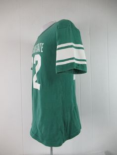 "Vintage 1970s or 80s college t shirt. Made of green cotton with thick white college graphics: Michigan State #22. Has Champion blue block label. Size large. Actual measurements are: 39\" around the chest 39\" around the waist 20\" shoulder seam to shoulder seam 28\" overall length In very good condition with 3\" of seam repair to the cuff." Champion T Shirt, College T Shirts, Blue Block, Michigan State, Green Cotton, Vintage 1970s, Vintage Tshirts, Vintage Clothing, Michigan