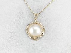 "Polished yellow gold is a luxurious accent in this Mabe Pearl pendant! This would make a wonderful piece for a bride and will look nice layered with other pendants. Bright diamonds provide a light, refreshing profile against the skin. This pendant does not come with the chain shown. Please feel free to contact us, we will help you find the perfect chain for your style and budget! Metal: 14K Yellow Gold Gem: Mabe Pearl Gem Measurements: 12.8 mm, Round Accents: 4 Diamonds totaling .06 Carats, H i Mabe Pearl, Vintage Pendant, Hand Engraving, Eternity Bands, Pearl Pendant, Diamond Pendant, Anniversary Gift, Bridal Jewelry, Anniversary Gifts