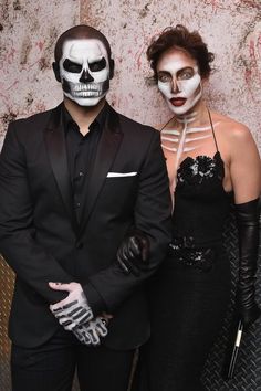 two people dressed up in costumes posing for the camera with their faces painted white and black