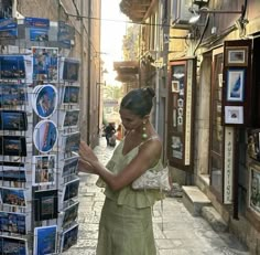 a woman is looking at pictures on the street