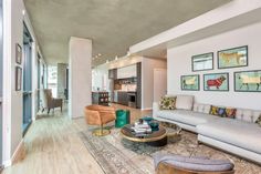 a living room filled with lots of furniture and decor on top of a hard wood floor