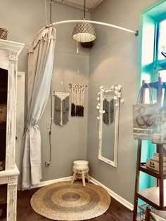 a bathroom with a round rug, mirror and shower curtain on the wall next to it