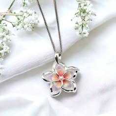 This Sterling Silver Plumeria Necklace is the perfect accessory for any special occasion. Featuring vibrant colors and delicate craftsmanship, this Hawaiian jewelry is perfect for any fan of elegant jewelry. An ideal gift for yourself or a special someone, this plumeria pendant is sure to make a lasting impression. - Comes ready to wear on a 925 sterling silver chain of you choice length. Comes standard on a box style chain.  - solid sterling silver plumeria flower pendant accented with a faux p Plumeria Necklace Jewelry, Silver Flower Shaped Jewelry For Mother's Day, Multicolor Flower-shaped Jewelry Gift, Multicolor Flower-shaped Jewelry For Gift, Elegant Sterling Silver Necklace With Birth Flower, Silver Flower Necklace For Anniversary, Delicate Multicolor Jewelry For Gifts, Multicolor Delicate Jewelry Gift, Silver Birth Flower Necklace For Mom