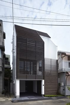 an apartment building with wooden slats on the front and side walls, along with two garages