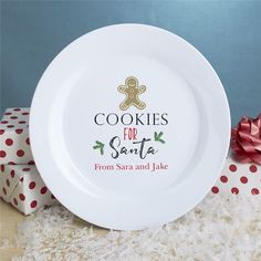 a white plate sitting on top of a table next to wrapping paper and a red bow