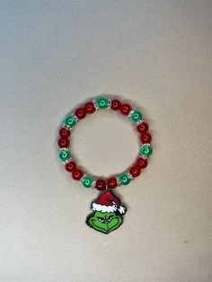 Adorable Grinch Bracelet - Perfect for Christmas and the Holidays! This charming bracelet features stunning red and green beads complemented by silver spacers. Red Jewelry For Christmas Holiday, Red Christmas Jewelry With Colorful Beads, Festive Christmas Beads With Round Shape, Red Beaded Christmas Jewelry, Festive Christmas Beads, Christmas Festive Round Beads, Festive Green Beaded Bracelets With Colorful Beads, Festive Green Beaded Bracelets, Red Round Beads Jewelry For Christmas