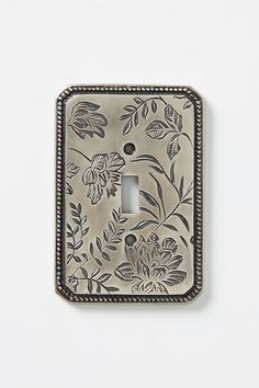 a light switch cover with flowers and leaves painted on the front, sitting on a white wall