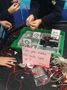 some kids are playing with wires and other things in a box that says can you make the buds light up?