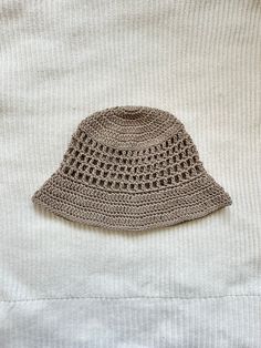 Protect yourself from the sun in style with this crocheted bucket hat with mesh-like details! This hat is made with 100% cotton yarn, so it is breathable and lightweight for warmer weather, and is washable. This listing is for an adult-sized hat in the color "taupe," more colors available in separate listings!  To clean, hand wash with cold water and lay flat to dry. Crocheted Bucket Hat, Vacation Hat, Tan Hat, Womens Hat, Crochet Bucket, Crochet Bucket Hat, Neutral Color, Sun Hat, Cotton Yarn