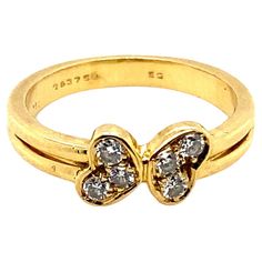 A vintage Cartier six stone diamond love heart ring in 18 karat yellow gold. The ring is designed as a pair of love hearts; each of which has been grain set with a trio of round brilliant cut diamonds leading onto a plain polished split 18 karat yellow gold band The six diamonds are of 0.15 carats in total approximately, assessed as G colour, VS1 clarity The simple and elegant design of this ring from Cartier mean that it can be worn as an everyday ring on its own or stacked with other rings for Cartier Yellow Gold Diamond Ring For Anniversary, Cartier Gold Ring With Single Cut Diamonds, Gold Cartier Diamond Ring For Anniversary, Cartier Gold Diamond Ring For Anniversary, Anniversary Gold Diamond Ring By Cartier, Cartier Yellow Gold Diamond Ring With Accents, Cartier Gold Diamond Ring Gift, Vintage Cartier Diamond Jewelry, Cartier 14k Gold Diamond Ring For Anniversary