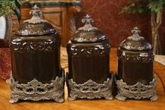 three brown canisters sitting on top of a wooden table