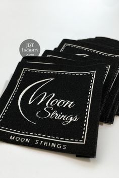 four black coasters with the moon strings logo on them