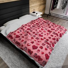 a bed with pink hearts on it in a bedroom