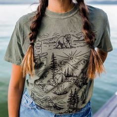 Our newest design for spring! We are so ready to explore the national forests this summer!! Unisex tee - model is wearing a medium Body Length 28 29 30 31 32 Chest Width (Laid Flat) 18 20 22 24 26 A Montana Scene Original Design. Printed in Montana. All designs are property of The Montana Scene. All rights reserved. All of The Montana Scene apparel is designed and printed locally in Montana. Come visit our storefront locations! Bigfork * Whitefish * Missoula * Kalispell * Bozeman Summer Outdoor Cotton T-shirt, Casual T-shirt For Outdoor Spring Activities, Casual T-shirt For Spring Outdoor Activities, Casual T-shirt For Outdoor Spring Events, Short Sleeve Tops For Outdoor Spring Activities, Short Sleeve Tops For Spring Outdoors, Short Sleeve Tops For Spring Outdoor Activities, Short Sleeve Tops For Spring Outdoor, Short Sleeve Tops For Spring Outdoor Events