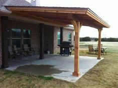 a covered patio with chairs and an outdoor bbq