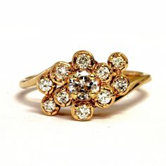 Exquisite 14 karat yellow gold cluster ring set to the center with a round-cut genuine diamond measuring approximately 4.28 millimeters in diameter and weighing an estimated .26 carats (SI1 clarity, G color), surrounded by 10 round-cut diamonds, each weighing .03 carats (VS1 clarity, G color), for a total carat weight for the ring of 0.56 carats. The ring is approximately 9.27 millimeters wide at the top and 2.29 millimeters wide at the shank. It weighs approximately 3.07 grams. It is a size 7, Yellow Gold Diamond Ring With Brilliant Cut Cluster, 14k Gold Cluster Diamond Ring With Vvs Clarity, Yellow Gold Diamond Cluster Ring For Anniversary, Yellow Gold Cluster Diamond Ring For Anniversary, Anniversary Yellow Gold Cluster Diamond Ring, Cluster Yellow Gold Diamond Ring With Prong Setting, Yellow Gold Cluster Diamond Ring With Prong Setting, Heirloom 14k Cluster Diamond Ring, Heirloom Yellow Gold Cluster Wedding Ring