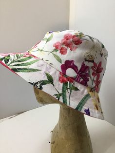 "Multi coloured floral sunhat has been sewn from a bright and pretty floral print.  This is a comfy and shady hat to wear on a hot day, take on holiday or down to the beach. The hat will fit most average sized heads and the fit can be adjusted with the inside elastic cord. Brim is topstitched.  The sunhat can be folded or rolled to keep in your bag.  Please check your head measurements with those below, allowing for some ease. Measurements  Inside.        60cms Brim           6 cms.      2 1/2\" Casual Brimmed Sun Hat With Floral Print, Summer Hat With Floral Print For Vacation, Summer Beach Hats With Floral Print, Adjustable Floral Print Sun Hat For The Beach, Casual Spring Sun Hat With Flower Shape, Summer Floral Print Sun Hat For Vacation, Spring Beach Sun Hat With Floral Print, Beach Sun Hat With Floral Print And Curved Brim, Adjustable Floral Print Sun Hat For Beach