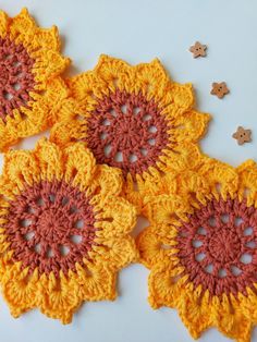 three crocheted doily are arranged on a white surface, with buttons in the background