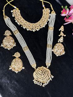 Beautiful jadau Polki Necklace layered with pearls this is intricate art done with expert craftsmen . Tika and Rings can be matched ton complete the look. light weight and Premium Quality.  Two styles shown one with long Rani Haar and another with just necklace. suitable if girl wants traditional look or brides mom for herself.  All Jewellery gets checked then dispatched. Immediate Dispatch available. No Exchange No Refunds. Comes in secured Box. Color shade displayed can vary slightly due to digital image limitations and Lighting.I hope its understood. Please expect these slight variations and imperfections when buying handmade jewelry. Jewellery Care:- Keep all Cubic Zirconia,American Diamond jewellery in a Ziplock Bag to protect it from Moisture and will last the Polish. Keep all Jewell Temple Jewelry Sets With Latkans For Wedding, Ceremonial White Sets With Tilla Detailing, Ceremonial Chandbali Sets With Latkans, White Bridal Sets For Eid Festive Occasion, White Bridal Sets For Eid Festivities, White Jewelry Sets For Wedding On Eid, Temple Jewelry Bridal Necklace With Latkans For Eid, Wedding Necklaces With Latkans For Eid, Chandbali Bridal Necklace For Eid Wedding