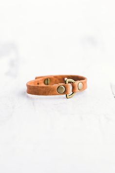 Handcrafted from lambskin leather, the Do Good bracelet features an antique brass D-ring with two large flat rivets. **Contents** * Lambskin leather, antique brass hardware * Button clasp closure * Handmade **Care/Import** * Made in the USA **Dimensions** * Adjustable to fit wrist sizes 6.5”-8” | Giving Bracelets Antique Brass Do Good Leather Bracelet at Free People in Orange Leather Bracelet Clasps, Adjustable Brown Jewelry With Antique Buckle, Gold Leather Bracelet With Brass Hardware, Brown Leather Bracelets With Brass Hardware, Vintage Leather Bracelet For Everyday, Adjustable Gold Leather Bracelet With Brass Hardware, Adjustable Brown Leather Bracelet With Brass Hardware, Leather Bracelet Diy, Good Bracelet