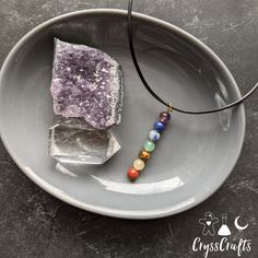 This natural Chakra stone drop pendant necklace is perfect for balancing and recharging your chakras. This necklace features 7 natural stones to represent each chakra (amethyst, lapis lazuli, sodalite, green aventurine, tigers eye, yellow Jade, and red Jasper) Pendant is hung on wax coated thread with a lobster claw clasp closure. Minimalist Gemstone Beads Necklaces For Healing, Spiritual Charm Necklaces With Gemstone Beads For Healing, Minimalist Gemstone Beads Necklace For Meditation, Holistic Gemstone Bead Pendant Crystal Necklace, Healing Natural Stones Round Pendant Charm Necklace, Holistic Crystal Pendant Necklace With Gemstone Beads, Spiritual Birthstone Crystal Necklaces With Round Beads, Spiritual Charm Necklace With Natural Stone Round Beads, Healing Crystal Dangle Necklaces With Gemstone Beads