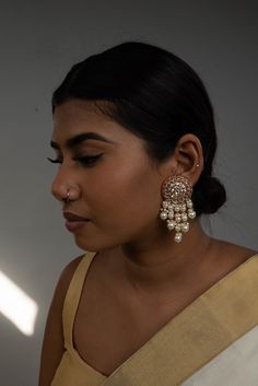 Add elegance and a unique touch to your outfits with our Pearl Rahi Earrings. Featuring a Hand-Crafted Pachi Kundan stud and drop pearls, and pearls on Gold plating, these earrings are a must-have in your jewelry box. Specifications Materials used: Pachi Kundan, Drop pearls, Gold plating At Romikas, we pride ourselves on the craftsmanship and high quality of our jewelry, designed to enhance your natural beauty. Please contact us with any questions. Luxury Fusion Style Pearl Earrings With Meenakari, Elegant Chandbali Beaded Earrings With Latkans, Pearl Chandbali Earrings For Receptions, Fusion Style Pearl Drop Earrings For Celebration, Elegant Pearl Earrings For Reception, Chandbali Pearl Chain Earrings For Celebration, Pearl Chain Chandbali Earrings For Celebrations, Pearl Drop Earrings For Reception, Elegant Pearl Drop Beaded Earrings For Festive Occasions