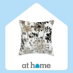 a white and black pillow sitting on top of a blue background with the words at home