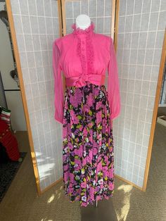 Awesome 1970’s hot pink maxi dress with pink flowers on black skirt. Long sheer sleeves, zipper up the back. One small stain on bust, rip in chiffon under one arm, and lighting discolored underarms inside the dressBust: 35/36”Waist: 28”Hips: 38”Skirt length: 38.5” Hot Pink Maxi Dress, Pink Floral Maxi Dress, Hot Pink Floral, Pink Maxi, Skirt Long, Peasant Dress, Pink Maxi Dress, Sheer Sleeves, Floral Maxi