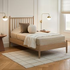 a bed sitting in a bedroom on top of a hard wood floor next to a window