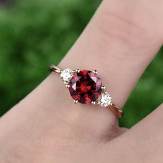 "This is a 1.25 carat garnet engagement ring in solid gold,about 7mm round cut. The accent stones are moissanites,forever classic quality. It can be made in any ring size. However please contact me to custom make it to a special big or small size. It can be made in white gold,rose gold or yellow gold with 14k or 18k. However for some people who are nickel allergic,I can also make it to 925 sterling silver to make you can wear it. The ring is handmade,very high quality! 30 days money back guarant Elegant Garnet Round Cut Rings, Brilliant Round Cut Lab-created Ruby Jewelry, Elegant Round Ruby Promise Ring, Elegant Jewelry With Lab-created Ruby For Promise, Elegant Lab-created Ruby Jewelry For Promise, Heirloom Lab-created Ruby Jewelry In Round Cut, Heirloom Style Lab-created Ruby Round Cut Jewelry, Classic Promise Jewelry With Lab-created Ruby, White Gold Garnet Jewelry For Promise Ring