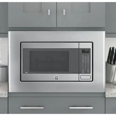 a stainless steel microwave oven sitting on top of a counter