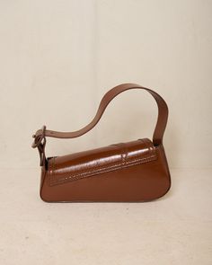 Trivia bag by Kiko Kostadinov in mahogany brown. The signature handbag silhouette from Kiko Kostadinov, presented in deep mahogany calf leather with intricate brogue detailing around the edges. Foldover flap with magnetic closure main compartment. Born in Bulgaria and based in London, Kiko Kostadinov launched his eponymous womenswear line in 2018, delving into an avant-garde aesthetic with innovative fabrics and architectural silhouettes. With Australians Laura and Deanna Fanning at the creative Avant Garde Aesthetic, Kiko Kostadinov, Mahogany Brown, Magnetic Closure, Trivia, Bulgaria, Calf Leather, In London, Product Launch