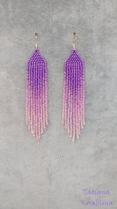 purple and pink beaded fringe earrings on grey carpeted area with small white beads