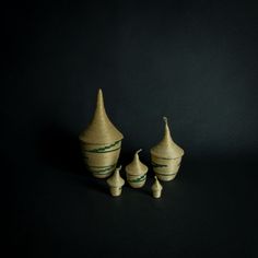 three small vases sitting next to each other on a black surface