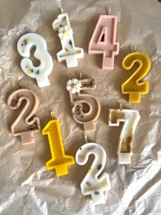 birthday candles are arranged in the shape of numbers on a sheet of waxed paper