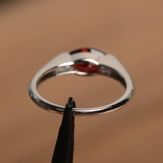 It is a natural garnet ring. The main stone is 5 mm* 10 mm marquise cut.weight about 1.35 carats. The basic metal is sterling silver and plated with rhodium. To change the metal to a solid gold (white/rose) or platinum is also available, please ask for a quotation if you want. You can also go to my shop Home for more elegant rings: https://www.etsy.com/shop/godjewelry?ref=hdr_shop_menu Garnet is January birthstone More garnet rings: https://www.etsy.com/shop/godjewelry?ref=seller-platform-mcnav& Marquise Garnet Ring For Anniversary, Garnet Gemstone Ring In Marquise Cut, Marquise Cut Garnet Gemstone Ring, Modern Garnet Rings For Anniversary, Silver Marquise Cut Ruby Jewelry, Silver Ruby Jewelry With Marquise Cut, Silver Marquise Cut Ruby Promise Ring, Silver Marquise Ruby Ring, Marquise Garnet Ring As Gift