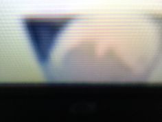 blurry image of person's face in front of television screen with white and blue colors