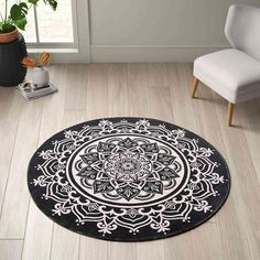 a black and white rug with an intricate design on the floor next to a chair