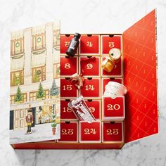 an open calendar on a marble surface with christmas decorations and gifts in the box next to it