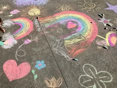 a child is drawing on the sidewalk with chalk