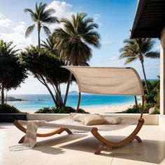 a hammock sitting on top of a white floor next to trees and the ocean