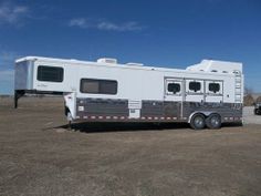 a horse trailer is parked in the dirt