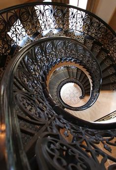 a spiral staircase with wrought iron railings