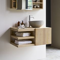 a bathroom with a sink, mirror and shelves