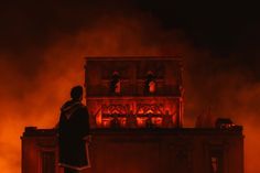 a man standing on top of a building next to a fire