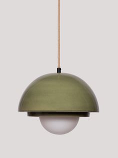 an olive green pendant light hanging from a rope