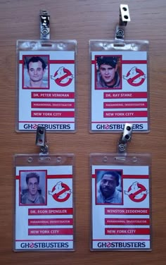 three id badges are hanging on a wooden table with clippings attached to them